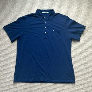 Navy blue short sleeve polo shirt with light blue Criquet emblem on pocket.